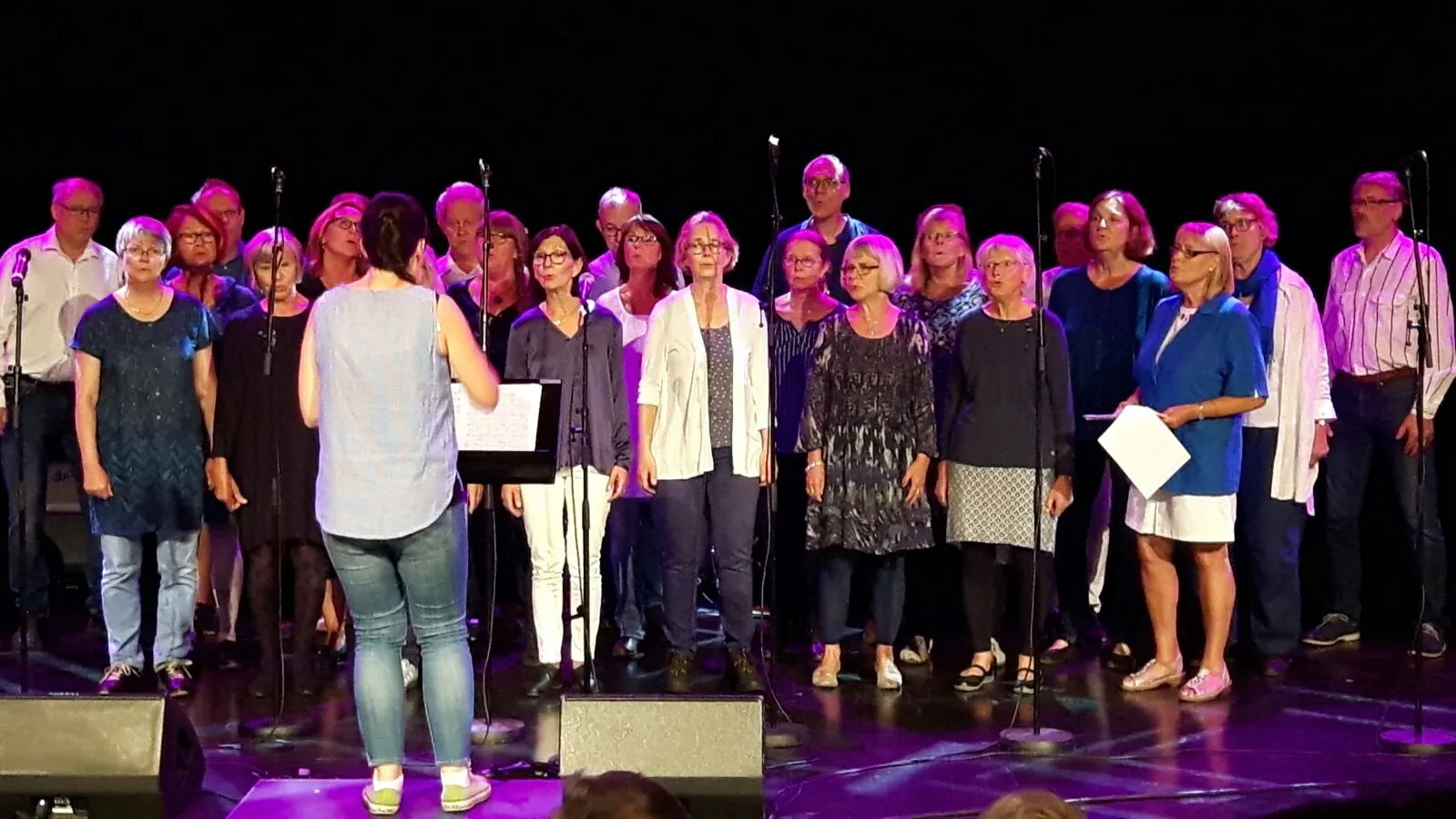 Fyra Vindar på scenen i UKK:s B-sal under Kulturnatten, med körledaren framför kören.